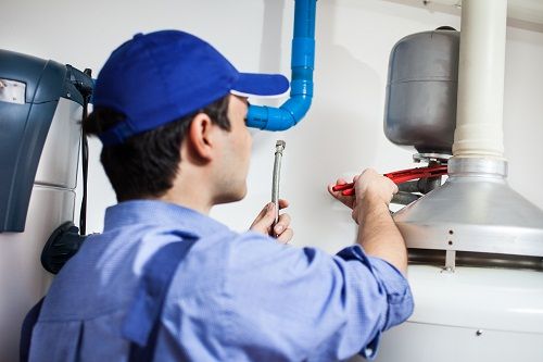 Plumber inspecting water heater